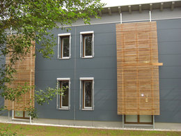 Anders als beim Altbau, der mit farbloser Holzbretterschalung verkleidet wurde, erhielt das neue Gebäude eine petrolblaue Fassade.