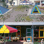 Der Außenbereich des Kindergartens präsentiert sich als grüne Oase, in der nachhaltiges Landschaftsdesign und Spielbereiche harmonisch miteinander verschmelzen. - SÄBU Holzbau