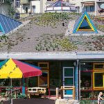 Eine beeindruckende Vogelperspektive zeigt das Gesamtgebäude des Kindergartens Luisenstrasse, eingebettet in die Umgebung, als Zeugnis für modernen Holzbau und umweltfreundliche Architektur von SÄBU Holzbau GmbH.